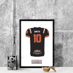 an orange and black football jersey hanging on a wall