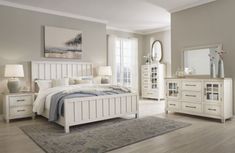 a white bed sitting in a bedroom next to a dresser and mirror on top of a hard wood floor