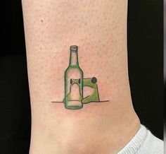 a woman's foot with a bottle and sewing machine tattoo on her left ankle