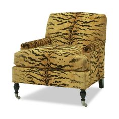 a tiger print chair sitting on top of a white floor next to a wooden leg