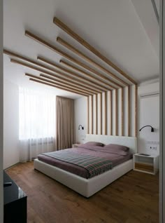 a large bed sitting in the middle of a bedroom next to a wooden flooring