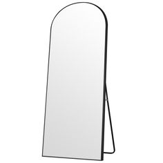 a mirror that is standing up against a white wall and has a black metal frame