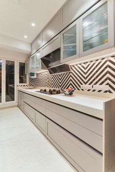 a kitchen with white counter tops and gray cabinets