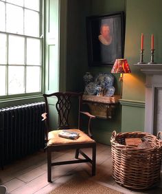 a room with green walls and a chair in front of a painting on the wall