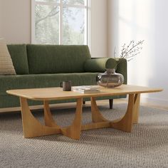 a living room with a couch, coffee table and vase on the carpeted floor