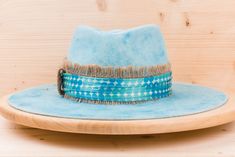 With this unique mediterranean turquoise fedora hat you will make a statement in the streets. This wide brim hat is perfect for all seasons. This boho hat is one of kind. Most of our hats are designed as unique pieces and carefully hand crafted in our atelier, paying special attention to every detail. Size specifications: Adjustable with half number. With a tie of a knot, adjust the fit of your hat to the ideal size. To know your hat size, use a soft measuring tape to measure the circumference o Artisan Turquoise Hat With Curved Brim, Artisan Turquoise Curved Brim Hat, Turquoise Fedora With Curved Brim For Festivals, Turquoise Fedora For Festivals, Handmade Turquoise Brimmed Hat, Blue Artisan Fedora With Adjustable Fit, Bohemian Blue Fedora With Flat Brim, Blue Bohemian Fedora With Flat Brim, Turquoise Bohemian Fedora With Curved Brim