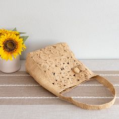 a sunflower sitting next to a straw bag