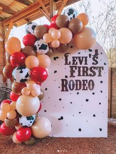 a sign that says levi's first rodeo with balloons in the shape of an arch