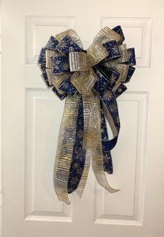 a blue and gold bow hanging on a white door