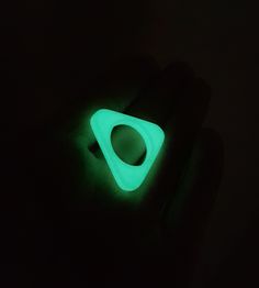 Triangular design glow in the dark ring. The triangular glowing ring is a real eye-catcher and conversation starter.  Both for men and woman, made exactly to your finger size. Comfortable to wear as the ring is light-weight. Don't forget to charge your ring. You can charge the green fluorescent by exposing the ring to (sun)light.  Glow in the dark -ReminderRings- help you to remind your goals and objectives, even in the dark.  Each time you have a look at the ring, you will automatically think of the underlying reason why you wear the ring. It's a straight-forward tool to achieve your (life) goals and create new and healthy habits. Elegant design, 3D printed in PLA material and polished by hand. Look can slighty vary due to manual finishing. Glow In The Dark Ring, Glowing Ring, Dark Ring, Glow Ring, Unique Ring Designs, Dark Rings, Goals And Objectives, Straight Forward, Sun Light