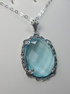 "Simulated Blue Aquamarine Necklace Bubble Design#P10 Custom Made Inspired by Victorian era designs, I now offer this lovely Antique reproduction in sterling silver. The flawless 22ct faceted simulated/Man-made blue Aquamarine is 24mm long (15/16th\") and 18mm in width (3/4th\"). The entire pendant is 1.5\" long and 7/8\" wide. The chain (if chosen) is between 16-18\" in length and is marked 925 as well. Notice the beautiful craftsmanship of the Victorian filigree setting. This pendant necklace Vintage Blue Oval Pendant Necklace, Elegant Blue Filigree Necklace, Blue Aquamarine Pendant Necklace, Blue Filigree Pendant Jewelry, Elegant Handmade Light Blue Necklace, Elegant Handmade Light Blue Necklaces, Elegant Light Blue Handmade Necklaces, Formal Blue Handmade Necklace, Formal Handmade Blue Necklace