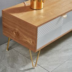 a wooden table with a gold cup on top and some metal legs next to it