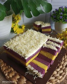 two pieces of cake sitting on top of a brown and white plate next to flowers