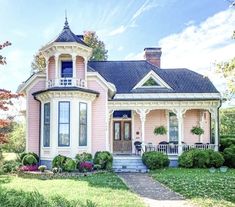 a pink house with white trim and black roof