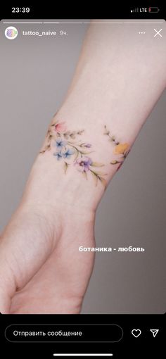 a small wrist tattoo with flowers on it