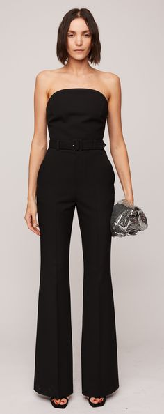 Crafted from our classic suiting material in a timeless black hue, the Kate Jumpsuit boasts a softly sculpted silhouette. It highlights flare legs and a strapless curved neckline with internal bone corsetry and a hook-and-eye panel for added structure and support along the bodice. Completing the ensemble are a belted waist and functional pockets for added convenience. Modern Structured Pantsuit For Formal Occasions, Evening Pantsuit With Structured Boning, Elegant Structured Pantsuit For Party, Sleek Structured Evening Pantsuit, Fitted Pantsuit With Structured Boning, Evening Suits With Structured Boning, Elegant Fitted Pants For Gala, Evening Tailored Pantsuit With Structured Boning, Luxury Tailored Evening Pantsuit