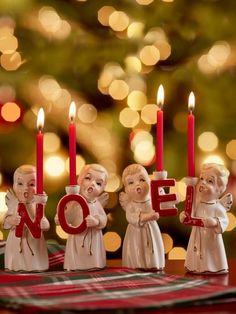 some little figurines sitting on top of a table with candles in front of them