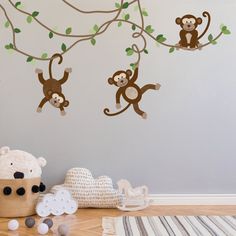 three monkeys hanging from the branches of a tree