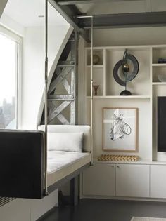 a living room filled with white furniture and lots of shelves on top of it's sides