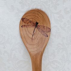 a wooden spoon with a dragonfly on it