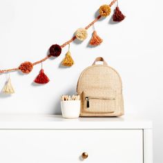 a backpack sitting on top of a white dresser