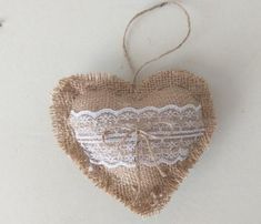 a heart shaped burlock hanging from a string with lace on it's sides