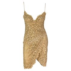 Presenting a stunning tan lace Donna Karan mini slip dress. From the Spring/Summer 1995 collection, the dress features intricate floral lace, a scalloped hem, a gracefully outlined bust, spaghetti straps, and a faux wrap detail. Made complete with the original brand tags still attached, this simply fabulous and irresistibly sexy vintage runway dress is a must-have! Approximate measurements: Size - 6 Bust: 28" - 34" Waist: 26" - 30" Hips: 38" - 44" Shoulder to hem: 34" 60% Cotton, 35% Rayon, 5% Nylon Evening Lace Dress With Scalloped Edges, Party Lace Dress With Scalloped Edges, Spaghetti Straps Lace Dress For Cocktail, Evening Mini Dress With Delicate Lace, Spaghetti Strap Lace Dress With Lace Work, Lace Sheath Mini Dress With Lace Trim, Lace Dresses With Spaghetti Straps, Fitted Lace Mini Dress With Scalloped Edges, Lace Slip Dress For Party