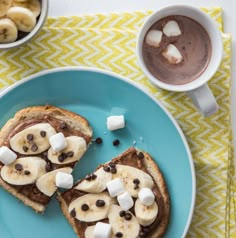 two pieces of toast with marshmallows and chocolate on them, sitting on a blue plate