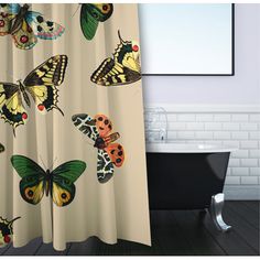 a shower curtain with butterflies on it and a bathtub in the corner behind it