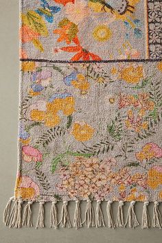 an old rug with flowers on it and fringes hanging off the side of it