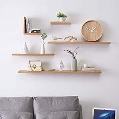 a living room with two couches and shelves on the wall above them that are displaying various items