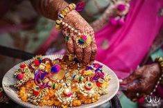 a woman holding a plate with lots of gold jewelry on top of her hand and hands