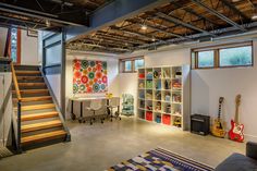 a living room filled with furniture and lots of bookshelves next to a stair case