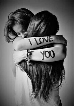 two girls hugging each other with i love you written on their arms behind the armbands