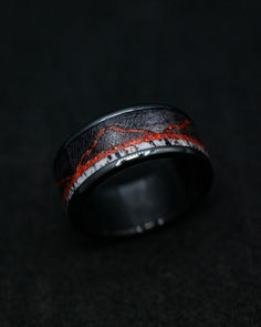 A "The Expedition" men's wedding band from Staghead Designs peeks out of the shadows. This black zirconium ring features dark maple wood, elk antler, & red opal mountains. Red Wedding Bands For Men, Men’s Mountain Wedding Band, Whiskey Barrel Wedding Ring, Engraved Wedding Ring, Green Engagement Rings, Antler Wedding Rings, Alternative Wedding Ring, Non Traditional Wedding Ring, Antler Wedding Band