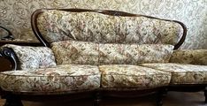 a couch and chair sitting on top of a hard wood floor next to a wall