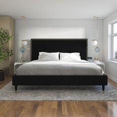 a large bed sitting on top of a hard wood floor next to a potted plant