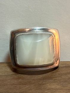 This is a beautiful, vintage, genuine Mother of Pearl /MOP and sterling silver ring. The ring is a size 6 1/2 and easily could be resized if needed larger or smaller. The ring features a rectangular-cut, bezel-set, natural white Mother of Pearl / MOP that is stunning at 5/8" in length by a little less than 5/8" tall or 15.88mm by a little less than 15.8mm. The Mother of Pearl /MOP is high-quality and the ring is very well-made. The ring face measures about 3/4" tall and the sterling silver ring Classic Adjustable Opal Ring For Anniversary, Vintage White Gold Opal Ring For Formal Occasions, Vintage White Opal Ring For Formal Occasions, Vintage Opal Ring For Anniversary With Polished Finish, Vintage White Gold Moonstone Ring For Formal Occasions, Classic Hallmarked White Opal Ring, Classic White Opal Ring, Antique White Moonstone Wedding Ring, Heirloom White Moonstone Ring For Formal Occasions