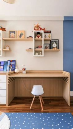 a child's bedroom with blue walls and white furniture, including a desk in the corner