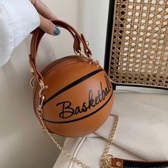 a woman holding a basketball bag on her shoulder