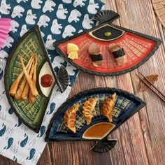 three plates filled with food on top of a wooden table next to utensils