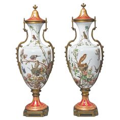 two vases with birds painted on them, one is gold and the other is white