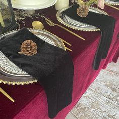 the table is set with pine cones and place settings