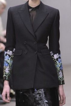 Introducing the epitome of elegance and style, our custom black cotton suiting floral embroidered jacket for women is a breathtaking piece that seamlessly blends sophistication with a touch of femininity. This double-breasted blazer exudes timeless charm and is meticulously crafted to enhance your formal ensemble, making it a perfect choice for weddings, bridesmaids, or even the bride herself. The intricately designed floral embroidery delicately graces the jacket, adding an enchanting allure to the attire. The black hue offers versatility, allowing you to pair it effortlessly with various outfits, while the tailored fit accentuates your silhouette and ensures comfort throughout the occasion. Elevate your outfit and make a statement with this bespoke, handcrafted jacket that embodies grace Formal Winter Outerwear With Floral Embroidery, Winter Formal Outerwear With Floral Embroidery, Formal Fall Outerwear With Floral Embroidery, Tailored Embroidered Blazer With Notch Lapel, Formal Fitted Outerwear With Floral Embroidery, Elegant Black Suit For Spring, Formal Floral Embroidered Outerwear For Fall, Fitted Outerwear With Embroidered Sleeves, Elegant Black Spring Suit