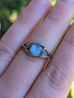 "\"Moonstone Leaf\" sterling silver ring. This ring was inspired by the way vines invade a forest and grow from every branch becoming a beautiful collage of foliage and embracing the trees and landscape around them. The vines on the ring flow around around the ring and over the Moonstone to create a beautiful scene or the tranquil embrace of the leaves. The ring features a 8mm Moonstone in a Solid Sterling silver mounting and will make the perfect artistic accent to show off your personal style. Nature-inspired Silver Moonstone Ring, Nature-inspired Moonstone Ring As Gift, Nature-inspired Moonstone Ring For Gift, Nature-inspired Moonstone Rings For Gifts, Nature-inspired Round Moonstone Ring In Sterling Silver, Silver Nature-inspired Moonstone Ring, Nature-inspired Sterling Silver Moonstone Promise Ring, Silver Moonstone Ring With Nature-inspired Style, Handmade Nature-inspired Round Moonstone Ring