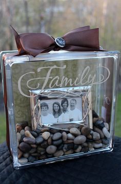 a clear box with some rocks in it and a ribbon on the top that says family