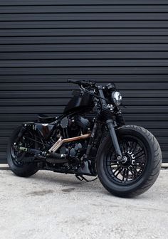 a black motorcycle parked in front of a garage door