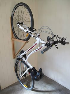 a bicycle is mounted on the back of a bike rack in a room with white walls