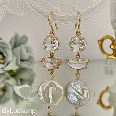 two pairs of earrings with pearls and crystal stones hanging from gold - plated hooks