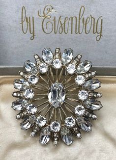 This stunning vintage 1940's Eisenberg fur clip is a must-have for any fashion jewelry collector. The piece is made of sterling silver and features beautiful clear rhinestones in a prong setting. The brooch is signed by the designer multiple times and has a weight of 63g. Length 2 3/4 inches approx Width 2 1/2 inches approx Weight 63g The fur clip is perfect for people who appreciate the classic look of vintage jewelry and the quality cannot be beat. The piece has a timeless appeal and can be wo Vintage Crystal Brooches For Formal Occasions, Glamorous Formal Jewelry Brooch, Glamorous Formal Jewelry With Brooch, Vintage Crystal Brooches For Anniversary, Glamorous Silver Brooch Jewelry, Rhinestone Costume, Rhinestone Costume Jewelry, Fort Wayne, Vintage Rhinestone